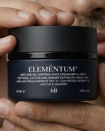 Person holding a jar of Elementum anti-age oil control face cream